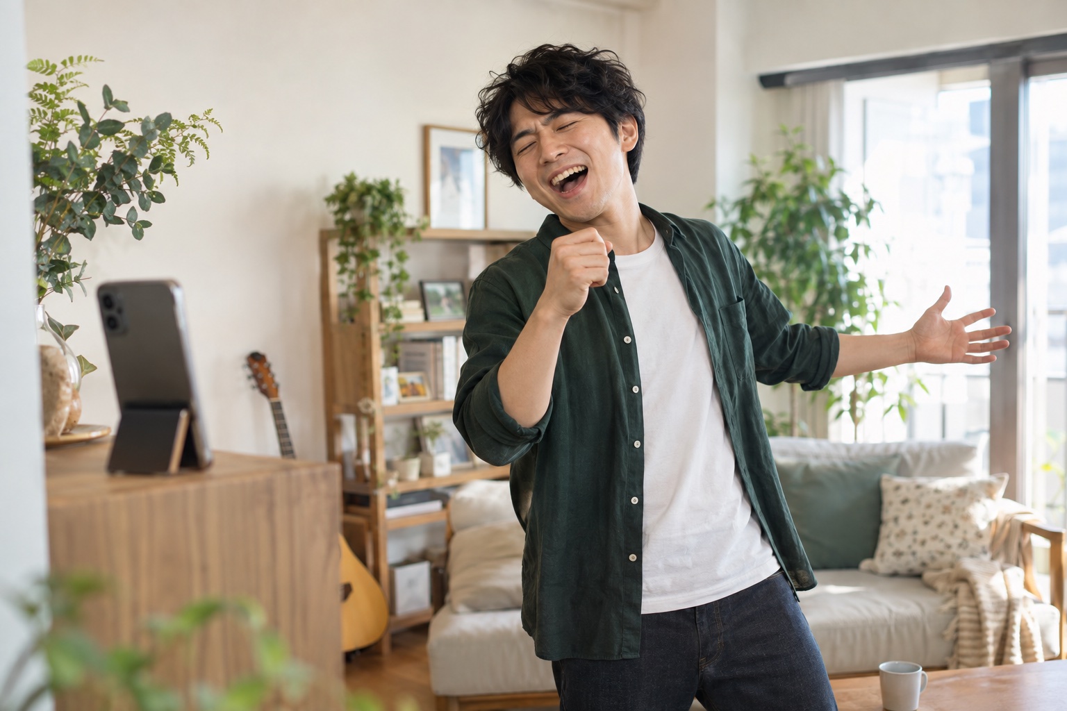 自宅でスマートフォンに向かって楽しそうに歌う男性。
